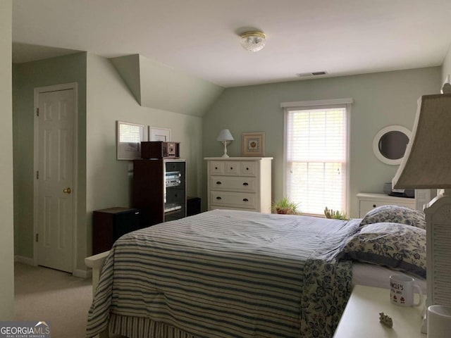 bedroom featuring vaulted ceiling and light colored carpet