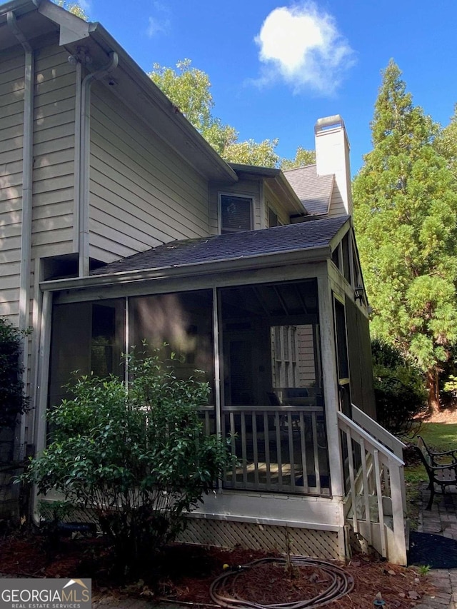2631 Gladstone Ter, Woodstock, GA 30189 - view of side of property featuring roof with shingles, a sunroom, and a chimney