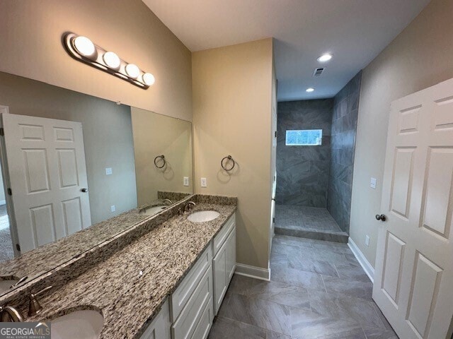 bathroom with vanity and a tile shower