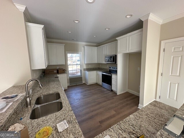 kitchen featuring white cabinetry, appliances with stainless steel finishes, light stone countertops, and sink