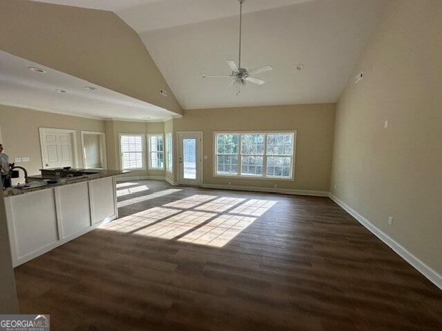 unfurnished living room with ceiling fan, dark hardwood / wood-style flooring, and high vaulted ceiling