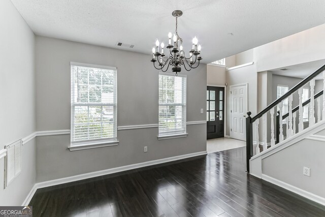 entrance foyer featuring wood-type flooring, a chandelier, and a textured ceiling