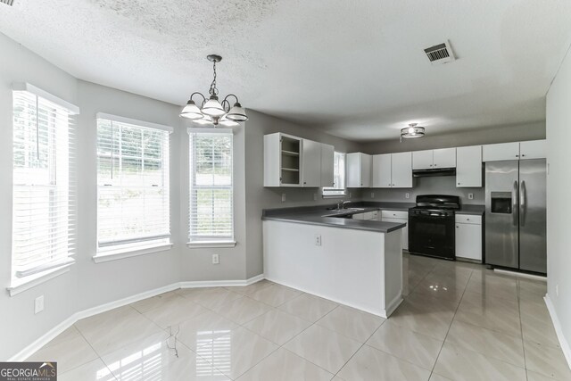 kitchen featuring black range oven, a chandelier, light tile patterned floors, kitchen peninsula, and stainless steel fridge with ice dispenser