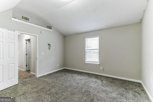 carpeted spare room with lofted ceiling