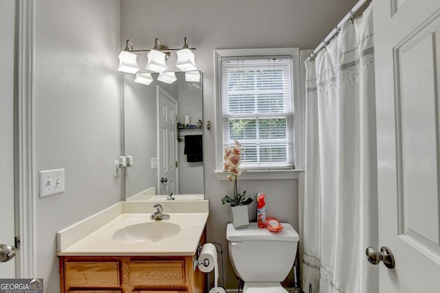 bathroom with vanity, toilet, and plenty of natural light