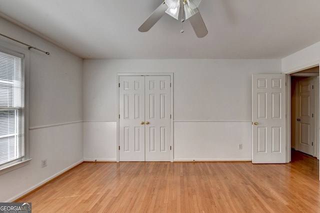 empty room featuring plenty of natural light, ceiling fan, and light wood-type flooring