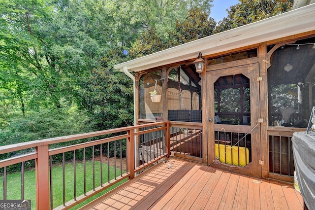 deck with a sunroom and a yard