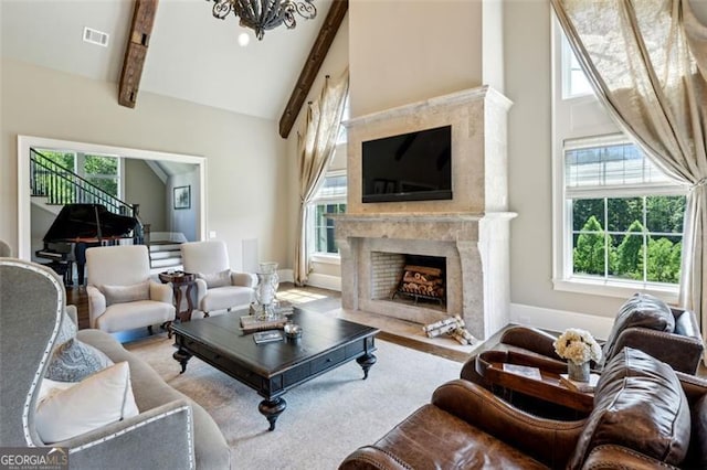 living room with a premium fireplace, a wealth of natural light, and beamed ceiling