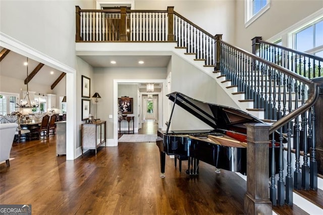 misc room featuring high vaulted ceiling, wood-type flooring, a chandelier, and beam ceiling