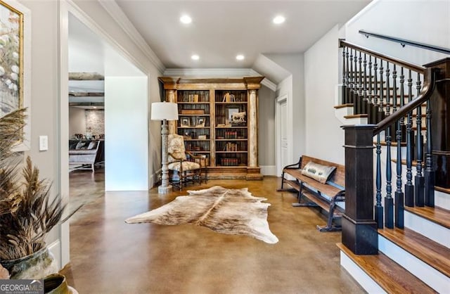 sitting room featuring concrete floors and ornamental molding