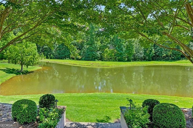 surrounding community featuring a lawn and a water view