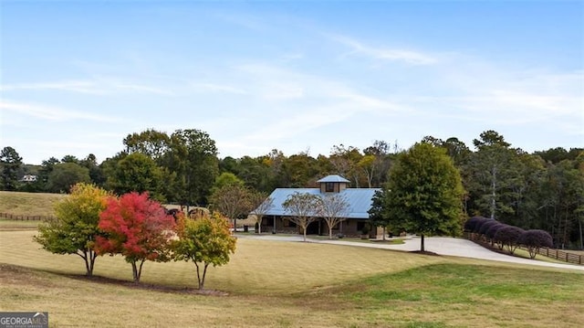 view of front of house with a rural view and a front lawn