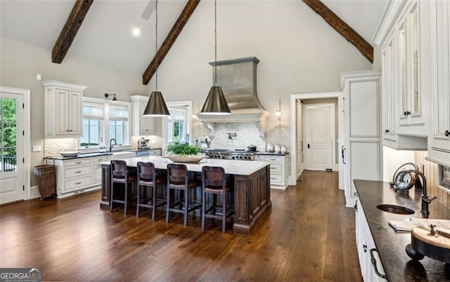 kitchen with beamed ceiling, a center island, dark hardwood / wood-style floors, and tasteful backsplash