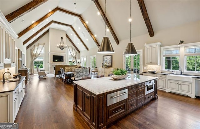 kitchen featuring a wealth of natural light, a center island, and a notable chandelier