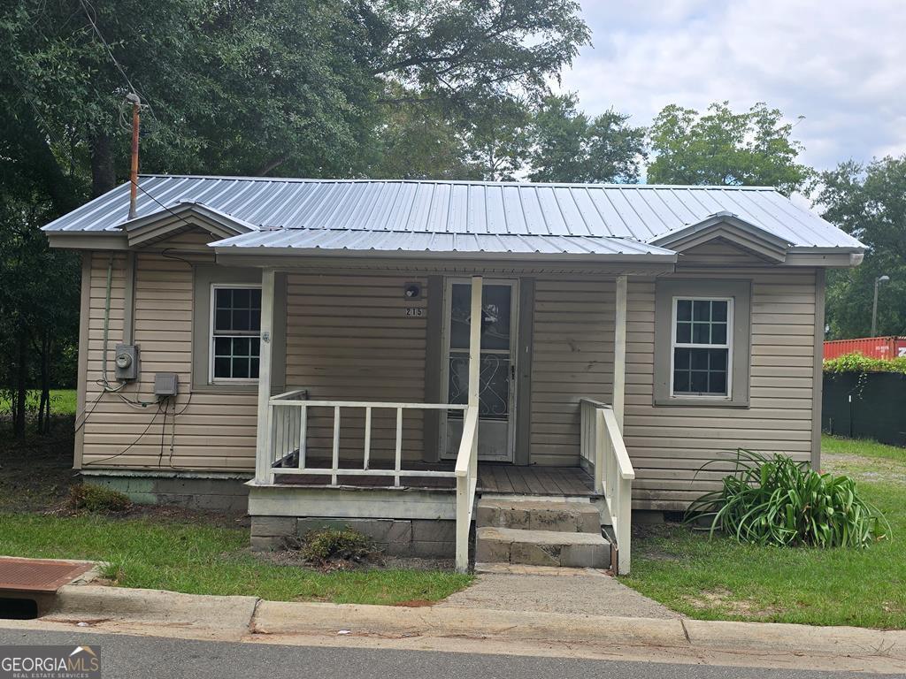 bungalow-style house featuring covered porch and metal roof