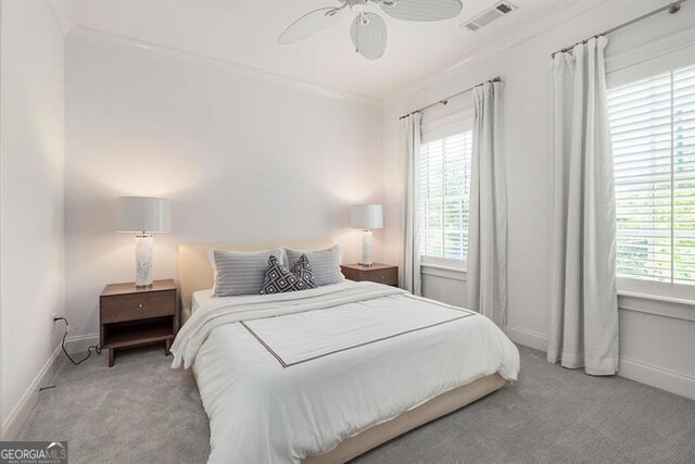 bedroom featuring light carpet, multiple windows, and ceiling fan