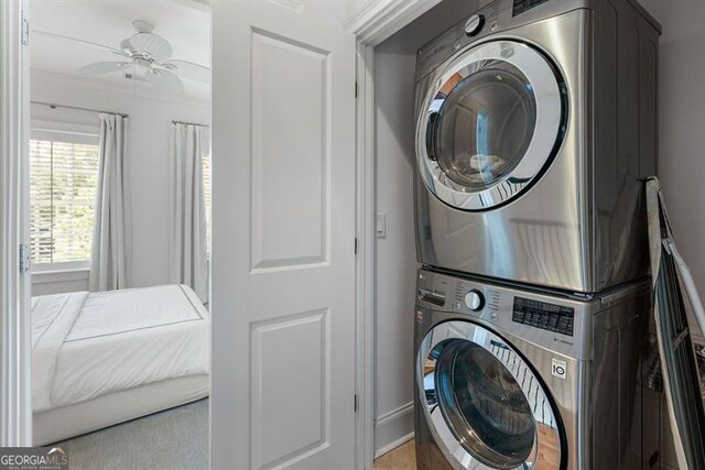 laundry room featuring stacked washer / drying machine and ceiling fan