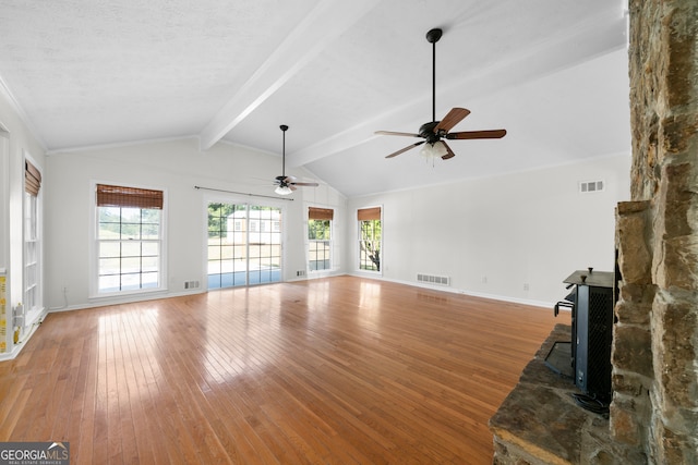 unfurnished living room with ceiling fan, hardwood / wood-style flooring, lofted ceiling with beams, and a textured ceiling