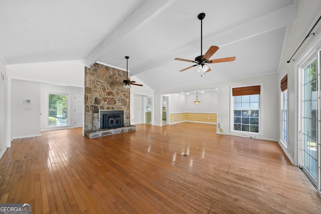 unfurnished living room featuring a fireplace, lofted ceiling with beams, ceiling fan, and light wood-type flooring