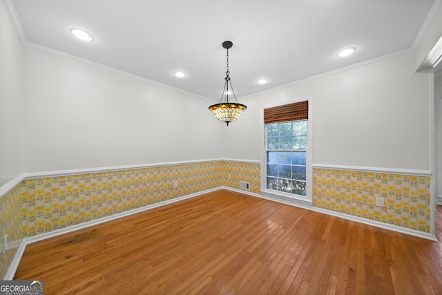 empty room featuring hardwood / wood-style flooring and ornamental molding