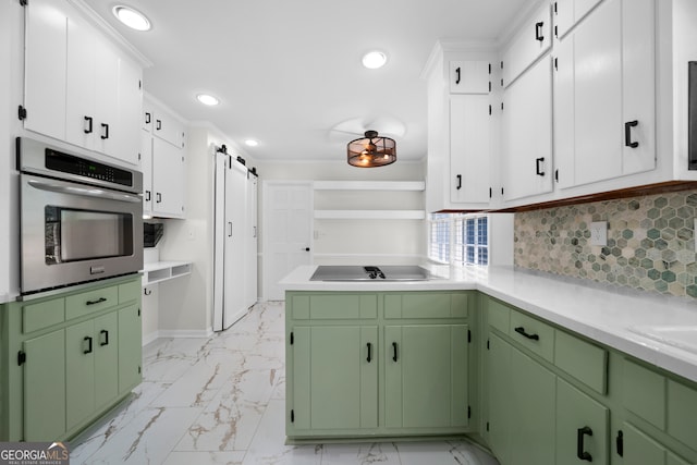 kitchen with oven, green cabinets, decorative backsplash, and a barn door