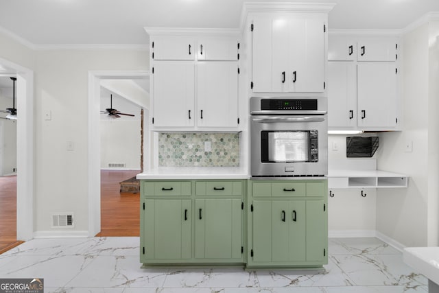 kitchen with oven, green cabinets, ornamental molding, white cabinetry, and ceiling fan