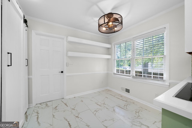 unfurnished dining area featuring ornamental molding and a barn door