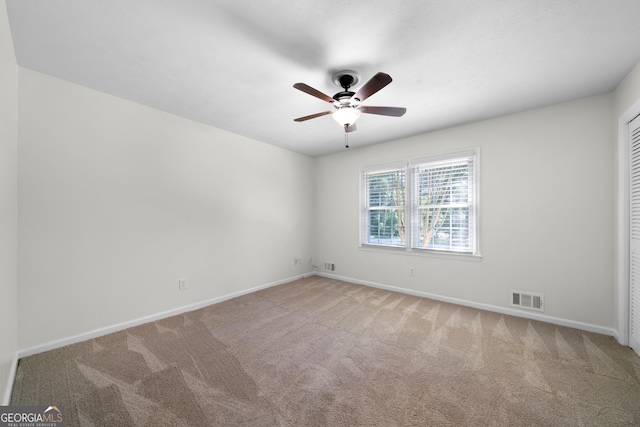 carpeted spare room featuring ceiling fan