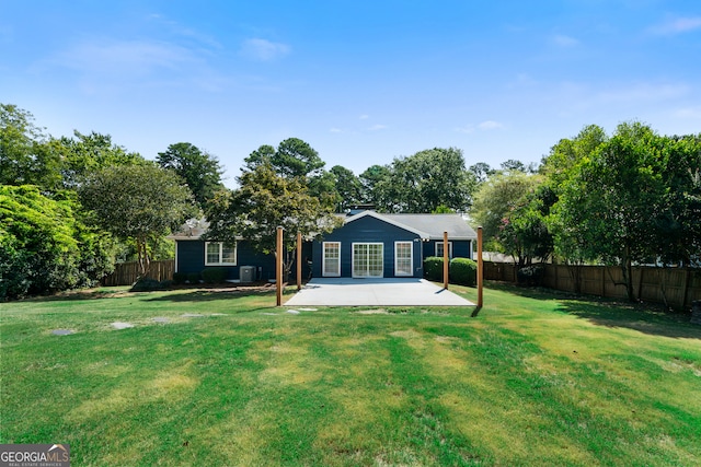 back of house with a yard and a patio