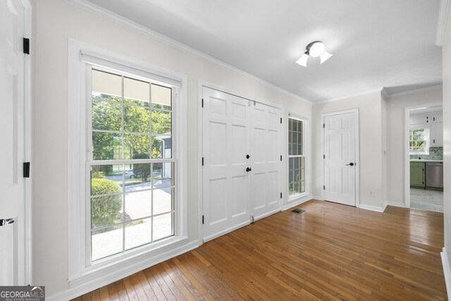 foyer entrance featuring hardwood / wood-style floors and crown molding