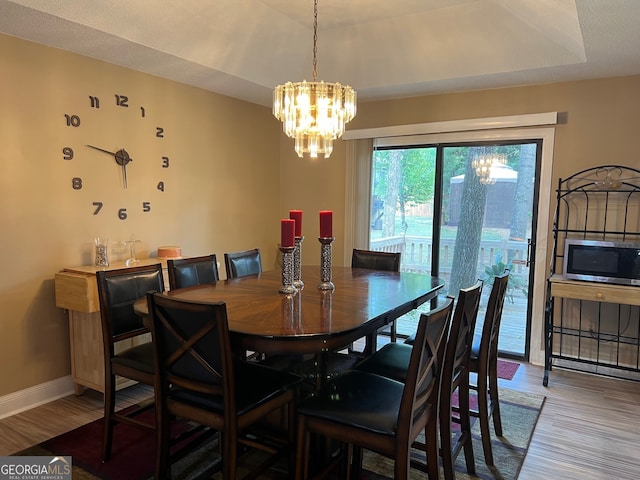 dining area featuring a textured ceiling, a notable chandelier, and light wood-type flooring