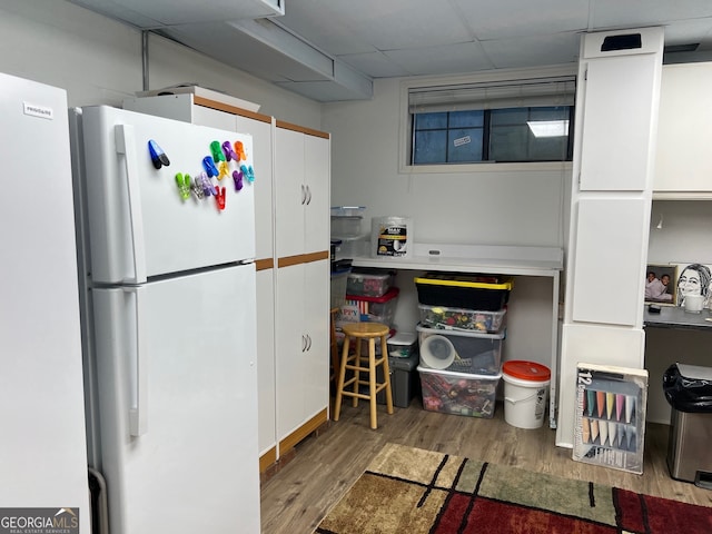 kitchen featuring white refrigerator, white cabinetry, and light hardwood / wood-style floors