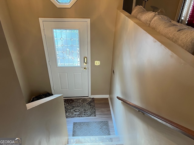 entrance foyer with hardwood / wood-style floors and a skylight