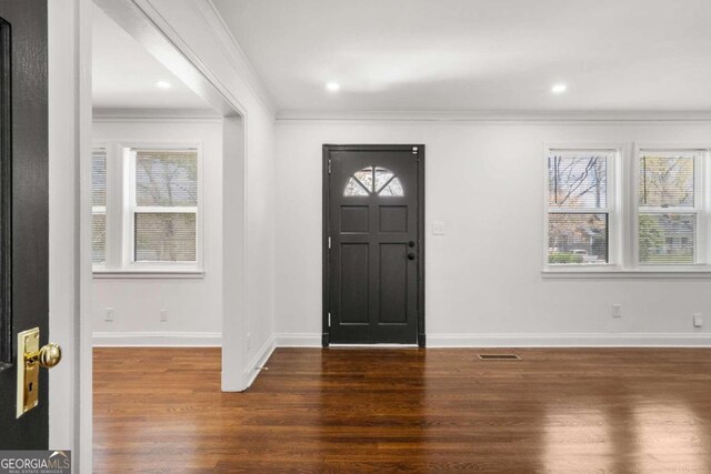 entryway with crown molding and dark wood-type flooring