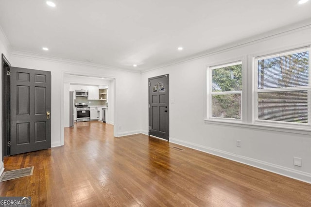 unfurnished living room with hardwood / wood-style floors and ornamental molding