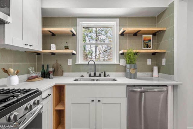 kitchen featuring white cabinets, tasteful backsplash, stainless steel dishwasher, and sink