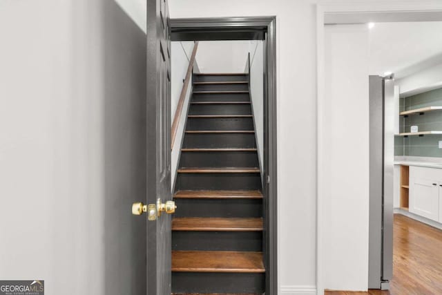 stairs featuring wood-type flooring