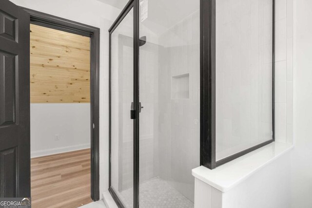 bathroom featuring hardwood / wood-style flooring and a shower with shower door