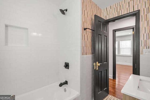 bathroom featuring tiled shower / bath, hardwood / wood-style flooring, and vanity