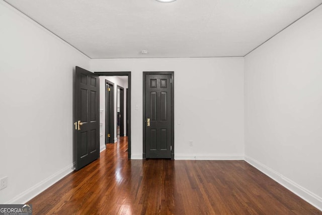 empty room with dark hardwood / wood-style flooring