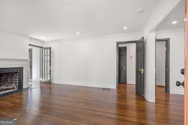 unfurnished living room with a tile fireplace, dark hardwood / wood-style flooring, and ornamental molding