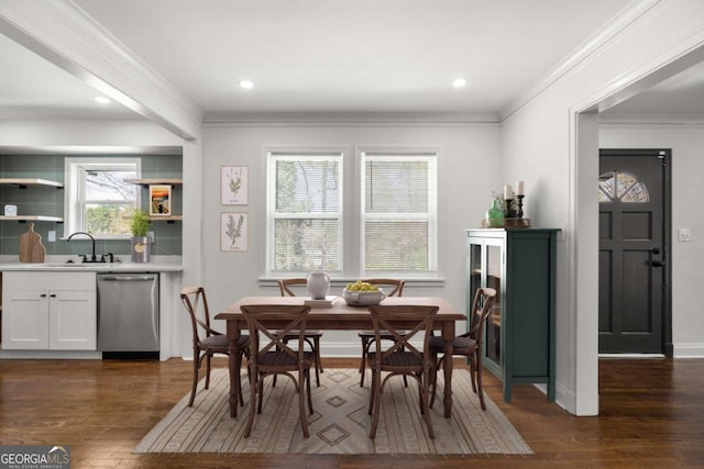 dining room with crown molding, sink, and dark hardwood / wood-style floors