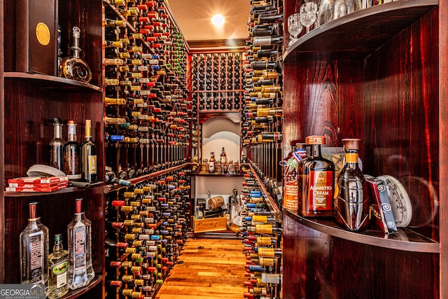 wine area with ornamental molding and hardwood / wood-style flooring