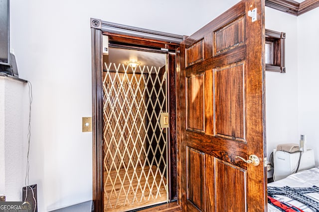 interior details with crown molding and elevator