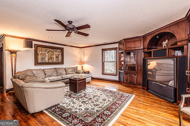 living room with a textured ceiling, crown molding, ceiling fan, and hardwood / wood-style flooring