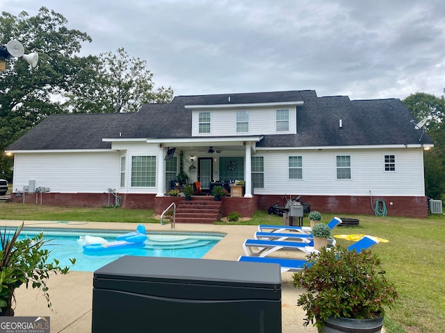 rear view of property featuring a patio area, ceiling fan, a yard, and central AC unit