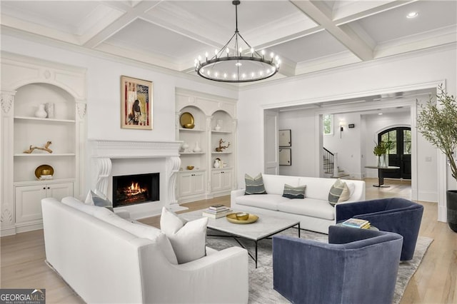 living room featuring coffered ceiling, beamed ceiling, a notable chandelier, light hardwood / wood-style floors, and ornamental molding