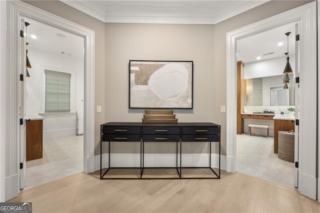 interior space with light wood-type flooring and ornamental molding