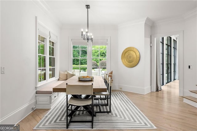 dining area with light wood-type flooring, a wealth of natural light, and ornamental molding