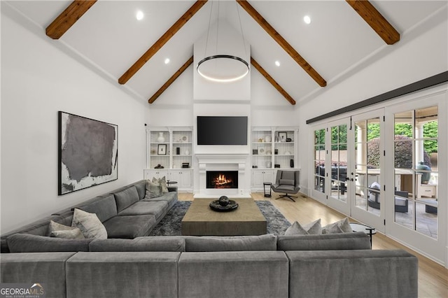 living room with french doors, high vaulted ceiling, beamed ceiling, and light hardwood / wood-style flooring